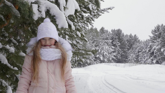 在冬季森林积雪中快乐的年轻女孩仰望着摄影机和笑笑冬天视频