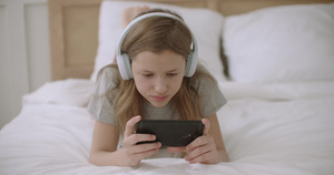 少女正在用智能手机上网从网站上阅读信息放学后躺在家里13秒视频