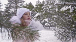女孩从棕榈树上吹雪把雪扔起来在森林中转过身来冬季降雪23秒视频