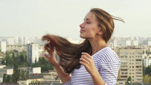 一个年轻女孩站在屋顶上享受天气的滋味13秒视频
