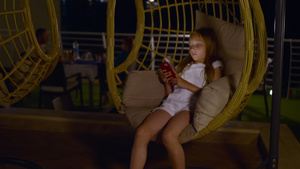 可爱可爱的十几岁女孩使用智能手机和睡在椰子摇椅上8秒视频