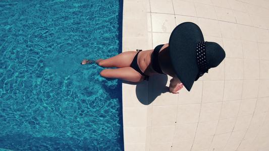 黑帽子和比金尼女人在游泳池顶层风景视频