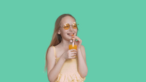 欢笑的少女带着眼镜穿着绿屏幕上喝着果汁的衣服23秒视频
