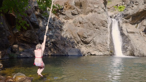 女孩少年在流动的瀑布景观上从蹦极跳入山区河流十几岁10秒视频