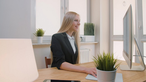 快乐的女性在办公室的电脑上工作微笑有魅力的女人穿着12秒视频