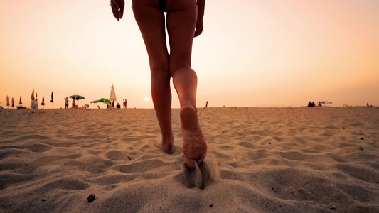 海滩旅行跟随时装模特女人走在沙滩上在沙滩上留下脚印视频