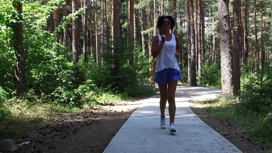 年轻女孩在森林公园慢跑慢动作视频