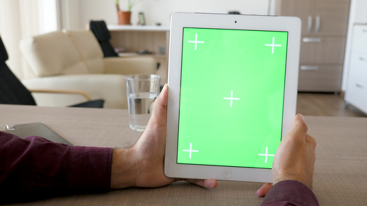 持有数字平板电脑的垂直位置并模拟绿色屏幕染色体视频