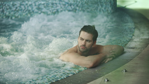 英俊男人在按摩浴池里休息性感男人在冬瓜浴池里放松按摩制服12秒视频