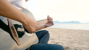 一个在海滩弹吉他的人7秒视频
