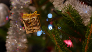 男人在圣诞树上挂着金色的圣诞礼物51秒视频
