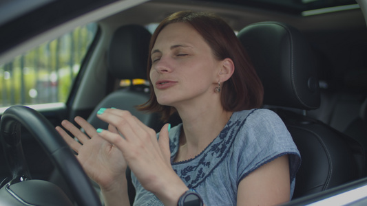 30岁的年轻女子坐在车里跳舞和唱歌观看女性驾驶员手舞视频