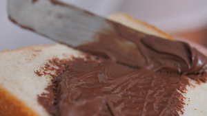 把巧克力奶油撒在一块面包上15秒视频