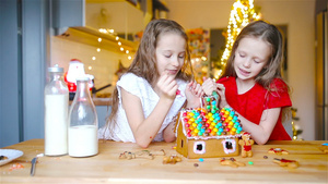 小女孩们在装饰的客厅壁炉里做圣诞姜饼屋11秒视频