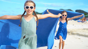 小女孩在热带度假期间享受海滩毛巾的风趣29秒视频