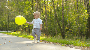 小男孩玩黄色的气球28秒视频