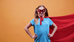 超级超级英雄的年轻女孩用红色斗篷和面具在她的眼睛上17秒视频