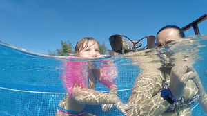 母亲和女儿在户外游泳池享受暑假21秒视频