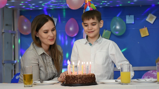 男孩在生日蛋糕上吹蜡烛视频