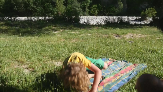 金发小男孩在草地上玩视频