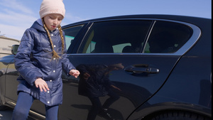 穿冬衣的少女在汽车旁边跳舞14秒视频