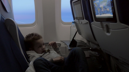 儿童在飞机智能手机上观看卡通视频