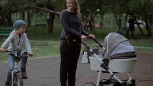 母亲与婴儿和大儿子一起在户外步行17秒视频