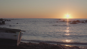 黎明或黄昏时分在海滩上的木船海浪小水中反射阳光31秒视频