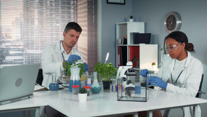 现代实验室科学家帮助他的同事进行试验在瓶中准备化肥29秒视频
