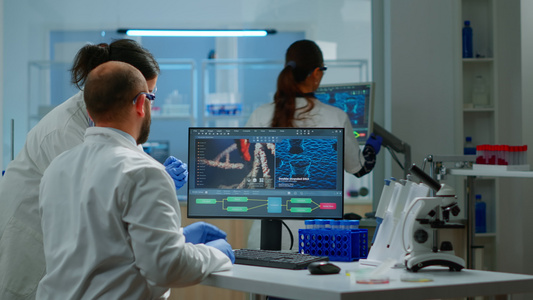 在现代设备齐备的实验室工作并使用计算机的科学家小组视频