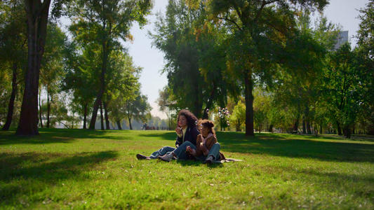 快乐的孩子妈妈在阳光明媚的公园里吹肥皂泡视频