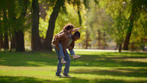 顽皮的父亲背着女儿在阳光明媚的公园享受家庭周末13秒视频