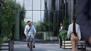 微笑的商务人士在现代办公大楼骑自行车23秒视频