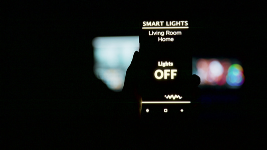 近距离拍摄一个手持智能手机的人用智能灯光应用程序握视频