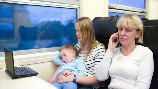 乘客在火车上观看笔记本电脑和电话的视频视频