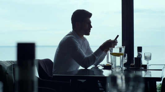 忙碌的商务人士在豪华餐厅午餐时在智能手机上阅读信息视频