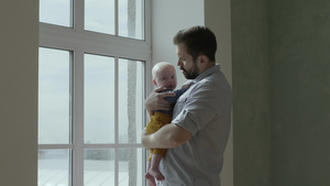 爸爸在窗户旁边抱着孩子12秒视频