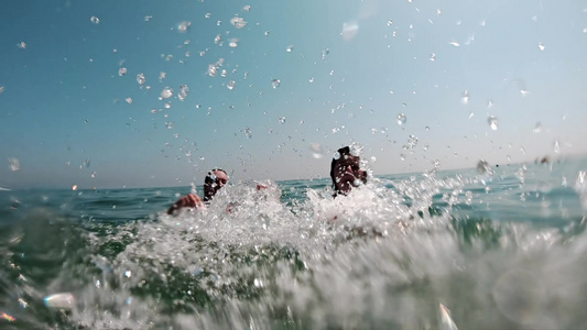母亲和女儿的慢动作在大海中互相冲浪玩得开心视频