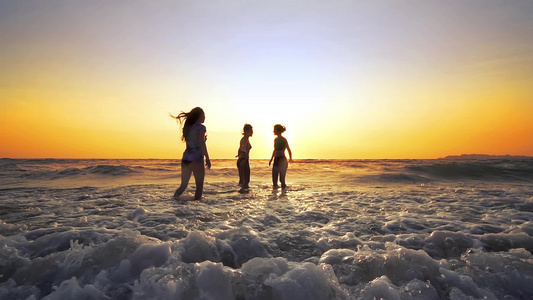 3名少女在日落的沙滩上跳舞和庆祝慢动作视频