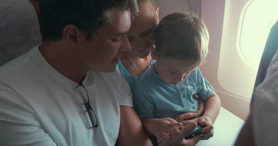 男孩用智能手机玩游戏他的父母视频