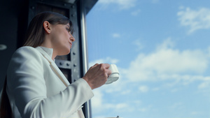 在多云的天空视图上喝咖啡的肖像女商务人士22秒视频