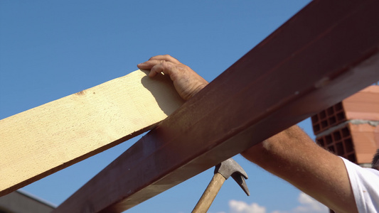 铁钉木板工人在屋顶安装工作上用锤子钉住木板视频