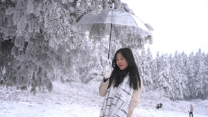 升格美女树下打伞遮下落雪花9秒视频
