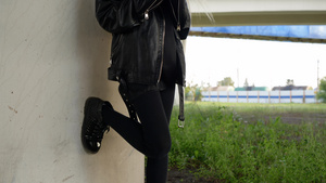 穿着黑色皮夹克的摇滚女孩在户外使用手机朋克女孩在城市18秒视频