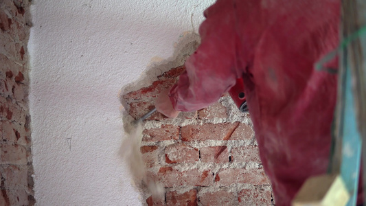 建筑工人用电锤拆除旧砖墙的废砖墙视频