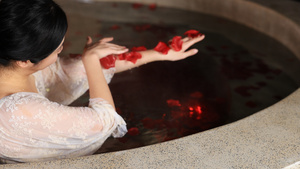 花瓣池中泡温泉的年轻女性21秒视频