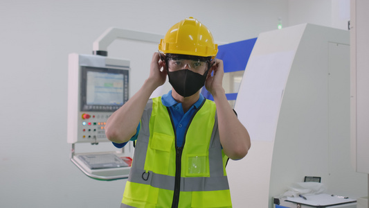 工厂工人在工作场所当着机器的面戴面罩安全和保护概念视频