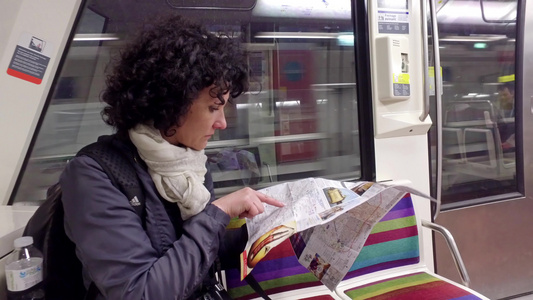 妇女乘坐地铁火车在帕里斯的地下地图上看一看视频