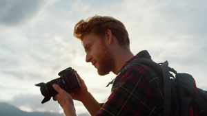 特写专业摄影师在日落山自然上拍照27秒视频