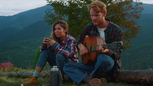音乐情侣在山地景观中露营视频